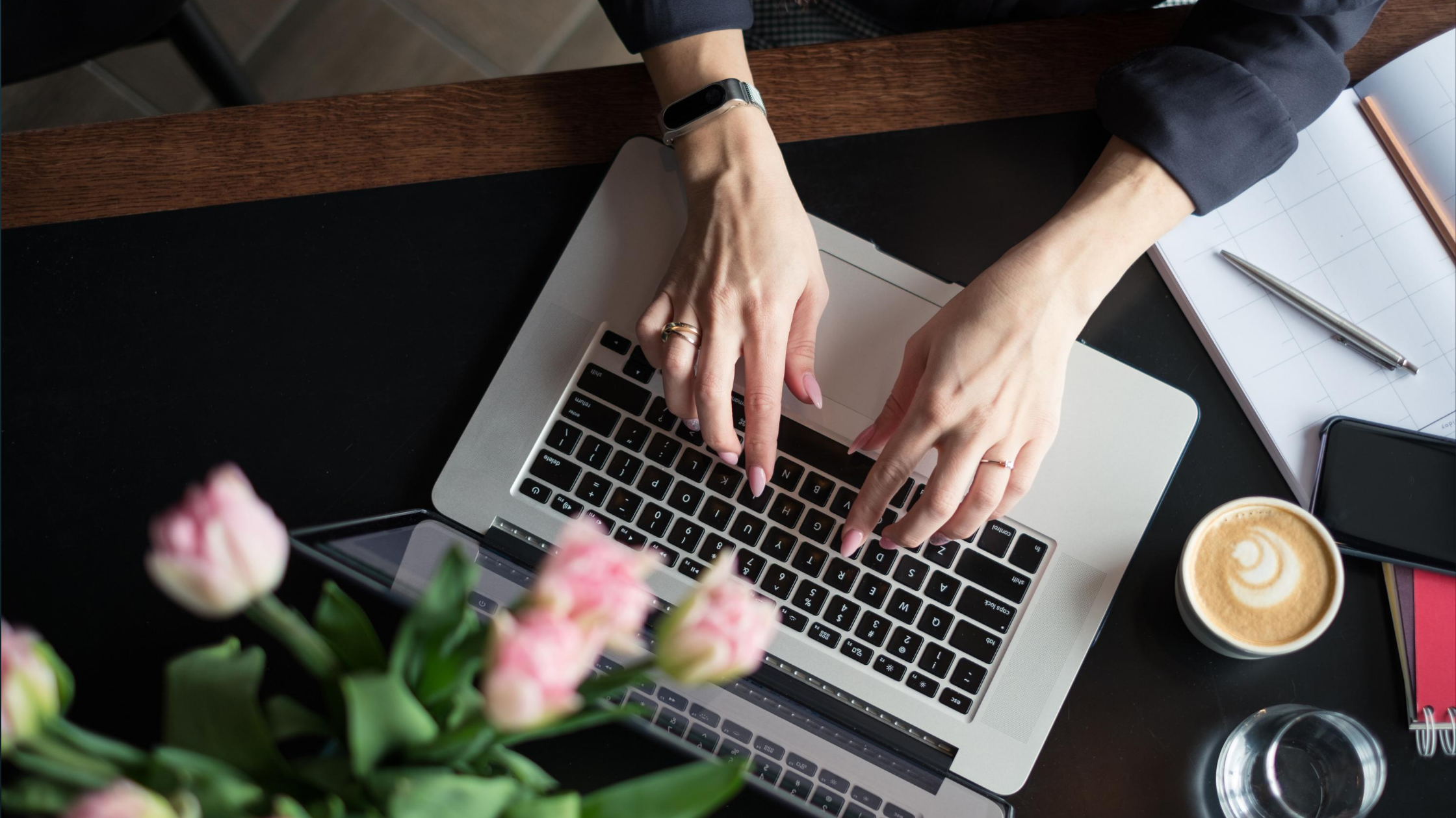 a woman's hands typing on a laptop keyboard