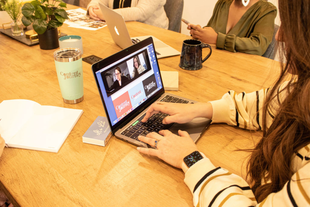 A woman sits at a table on a zoom call