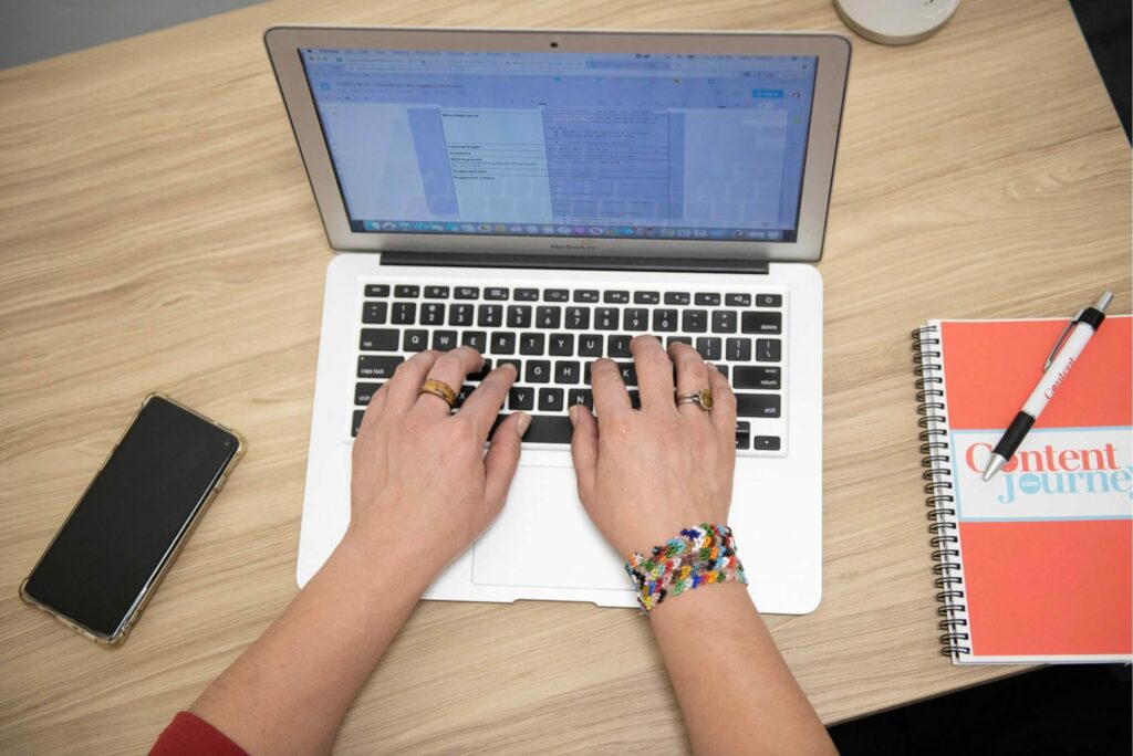 Hands typing on a laptop
