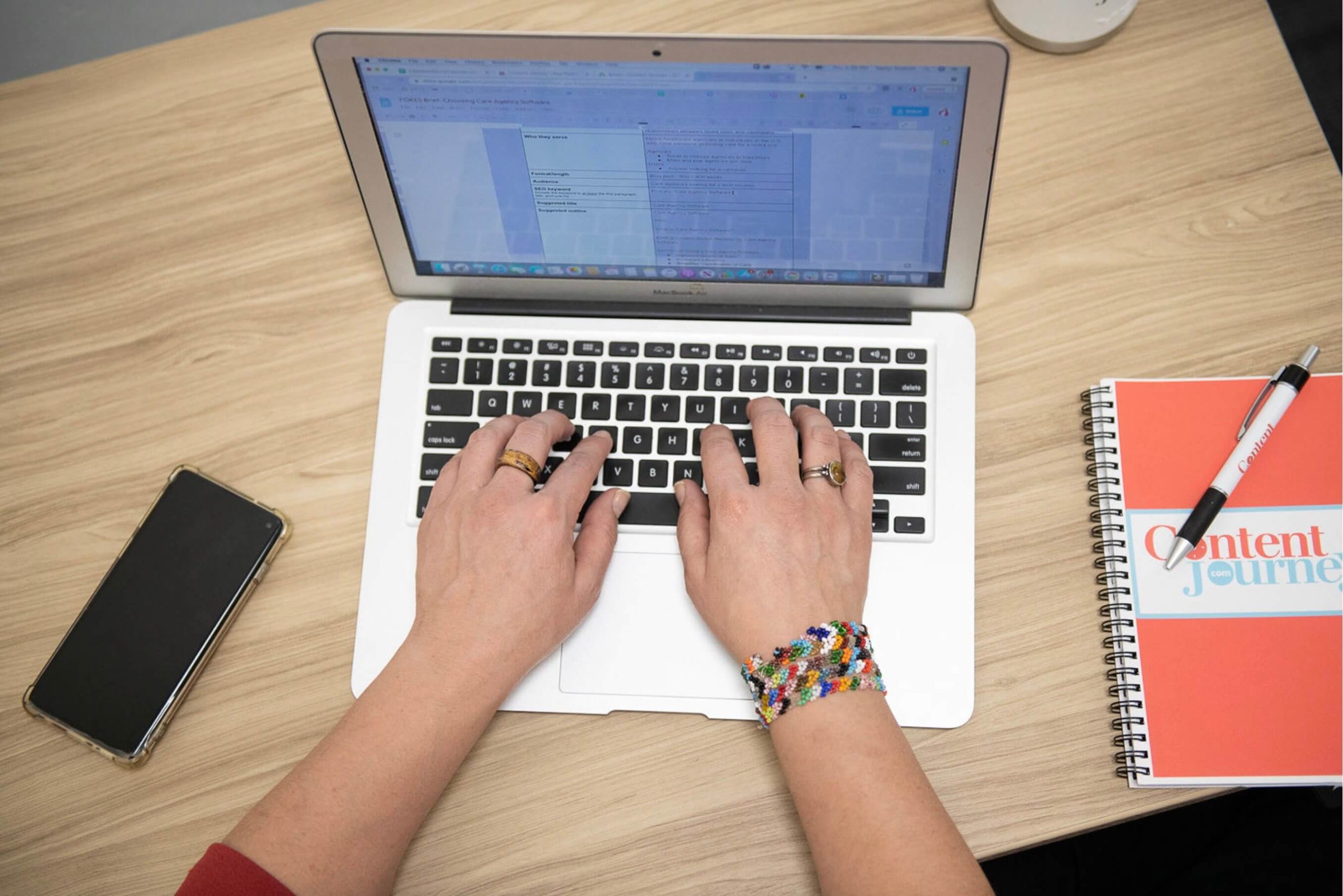 Hands typing on a laptop