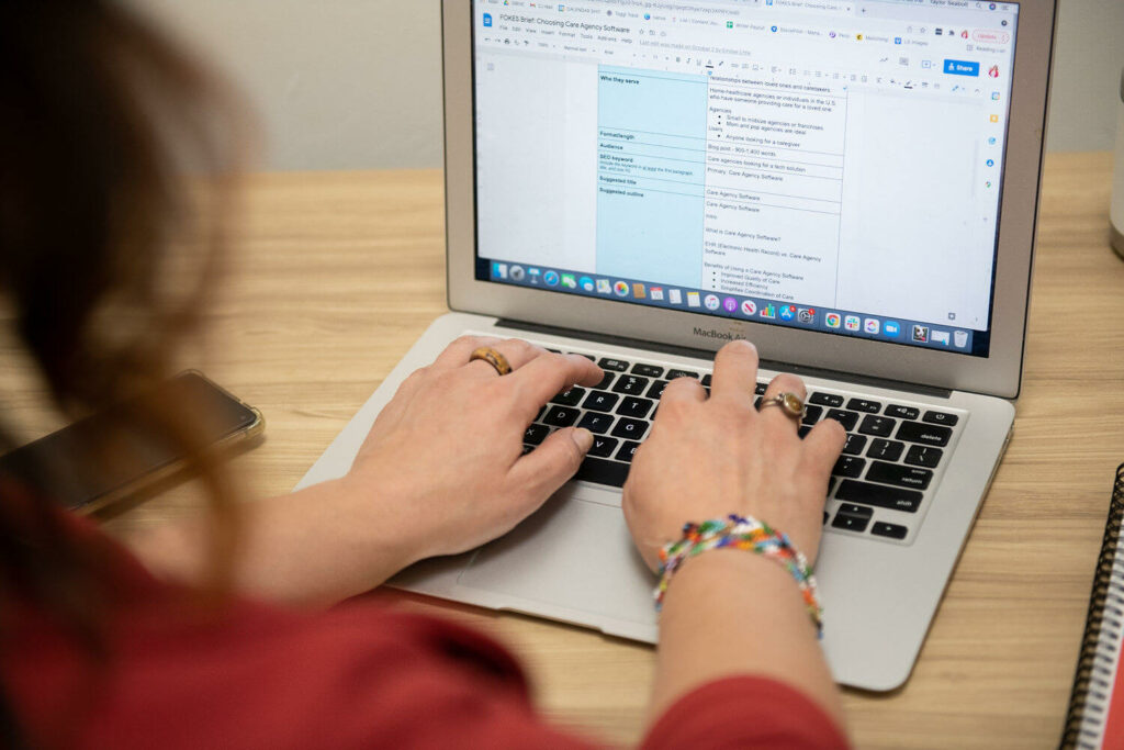 A woman types on a computer screen