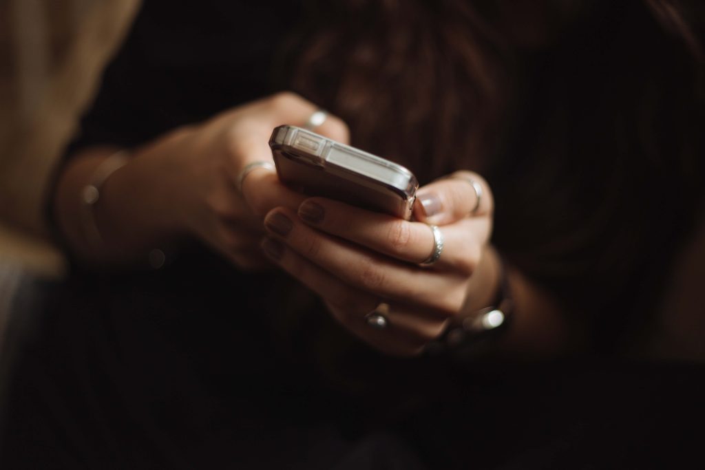 A close-up of a woman's hands holding an iPhone.