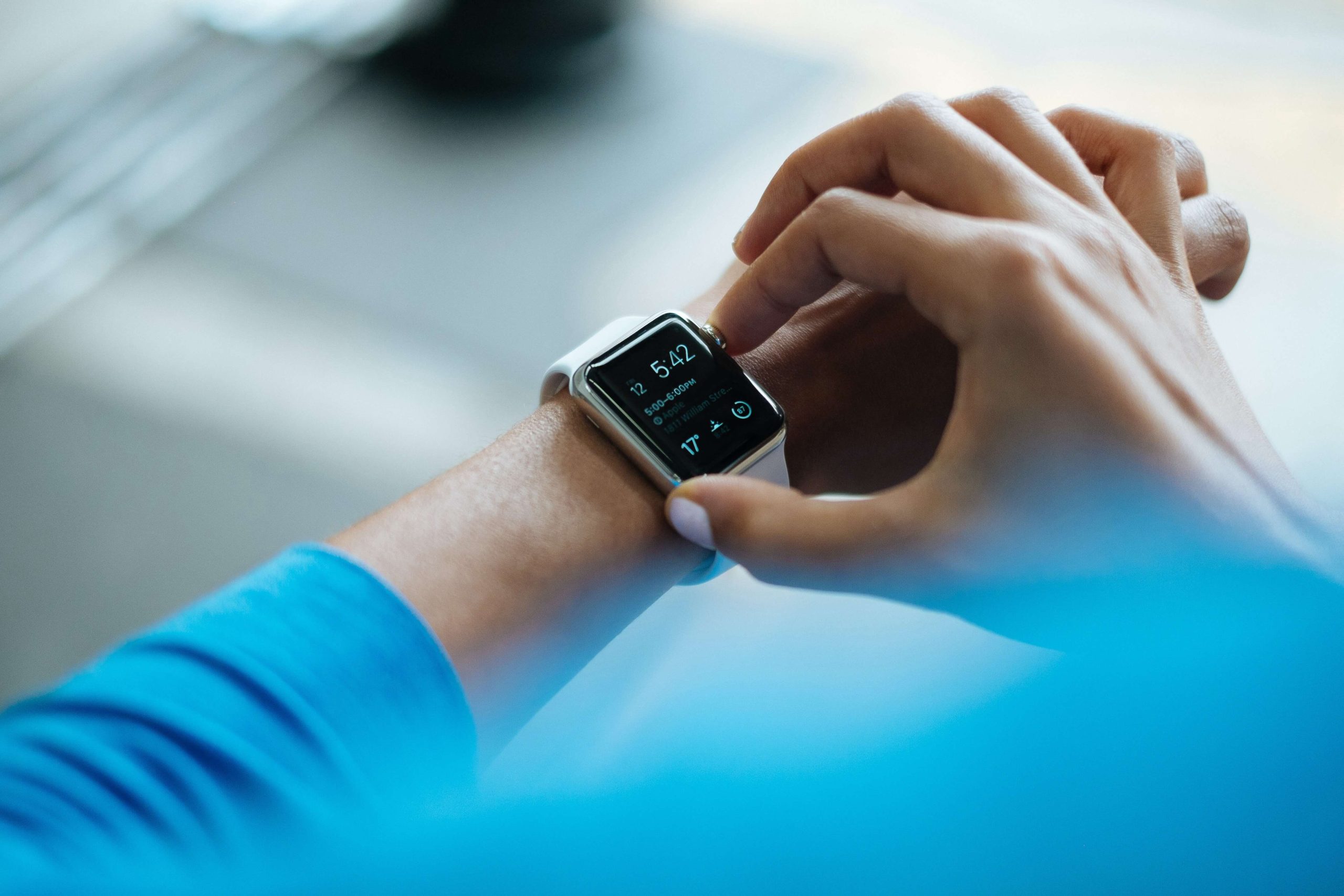 A close-up of a woman's hands selecting something on her smart watch